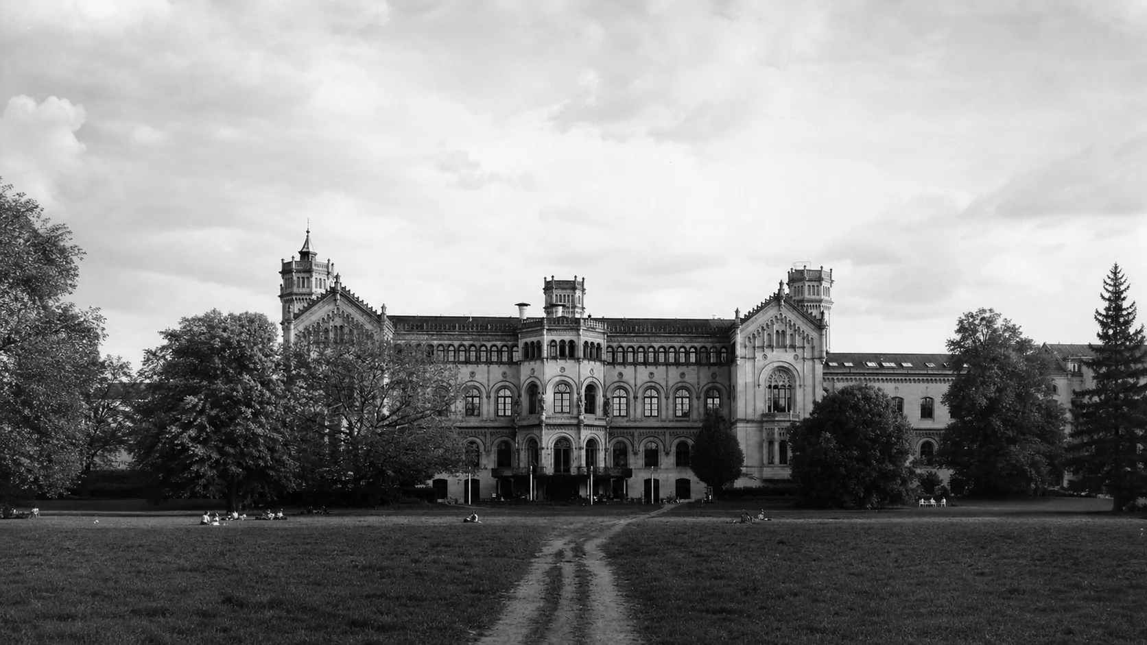 A historic European university building and the university park
