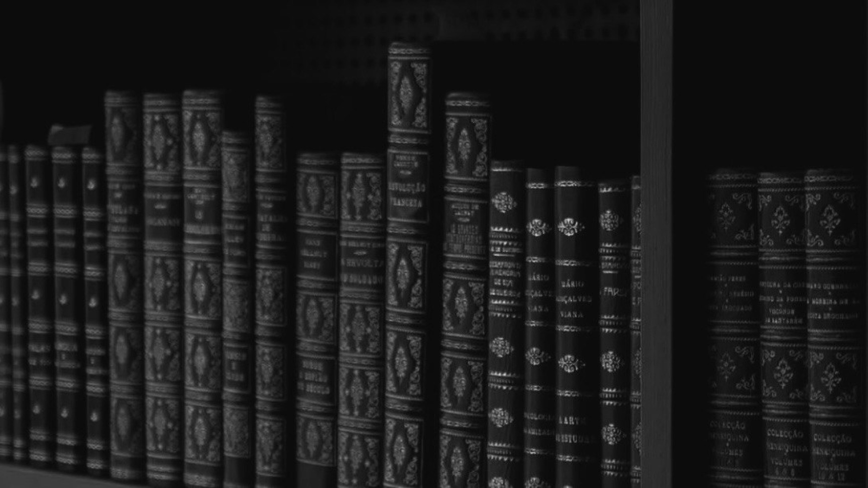 A black-and-white bookshelf of classic editions in dark bindings