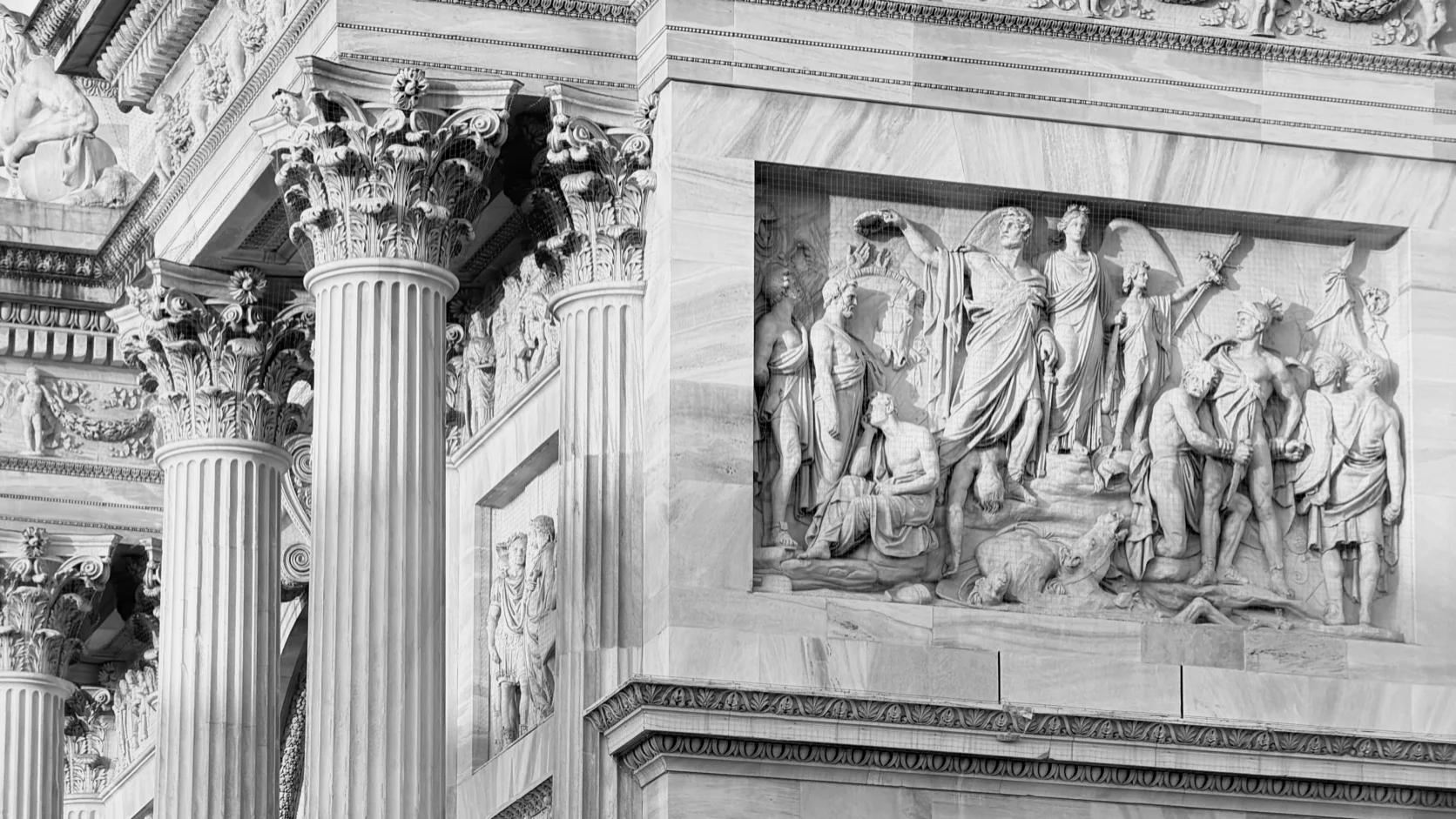 Corinthian columns and a marble relief on the facade of a neoclassical building
