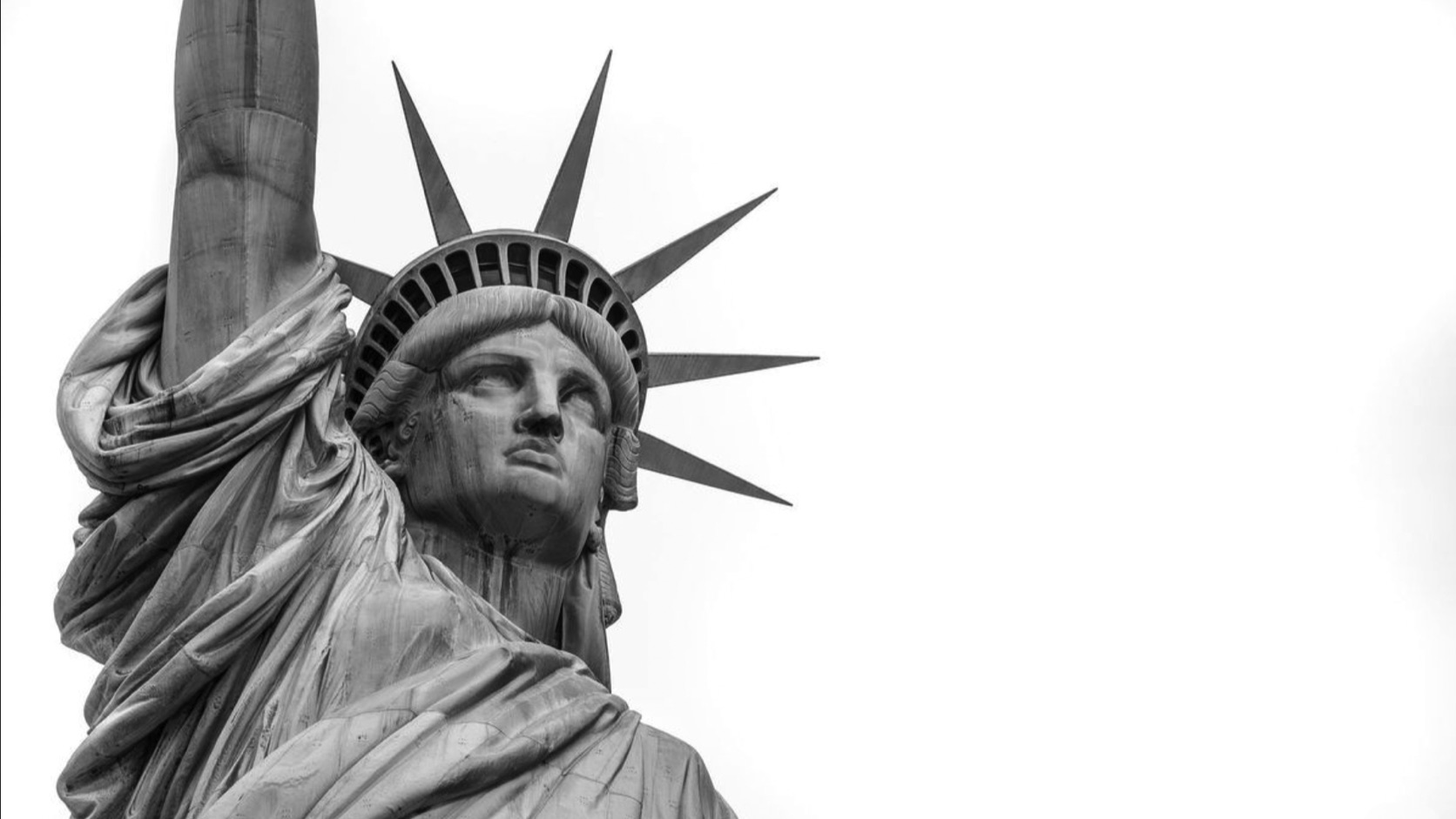Black-and-white close-up of the Statue of Liberty against a bright background